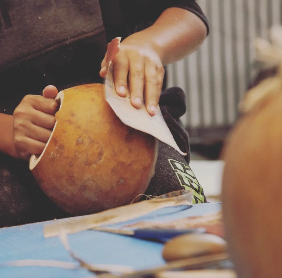 Artesão lixando a cabaça do berimbau